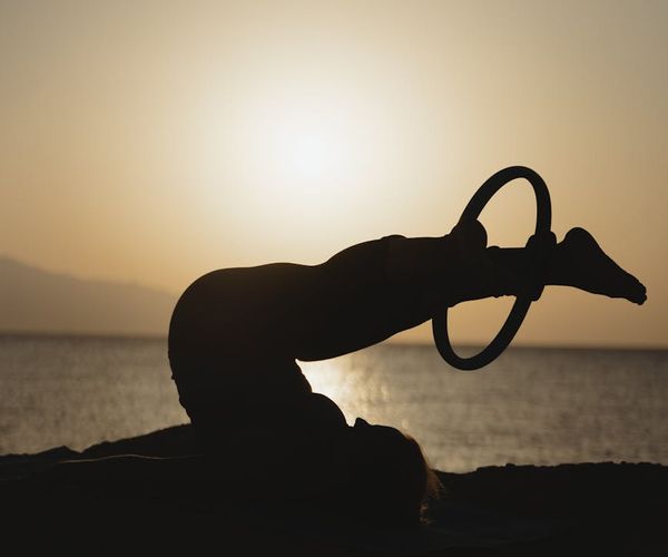 Person doing yoga at sunrise focused on flexibility